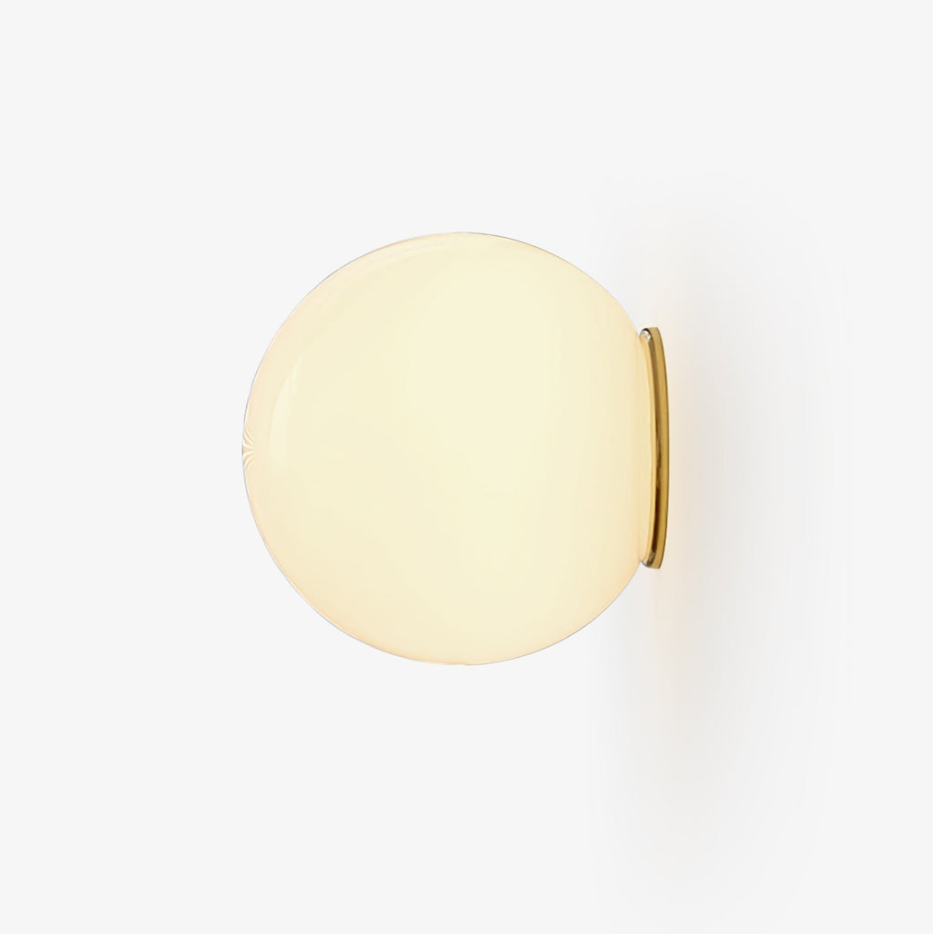 Glass orb wall sconce with brass base and white spherical glass shade
