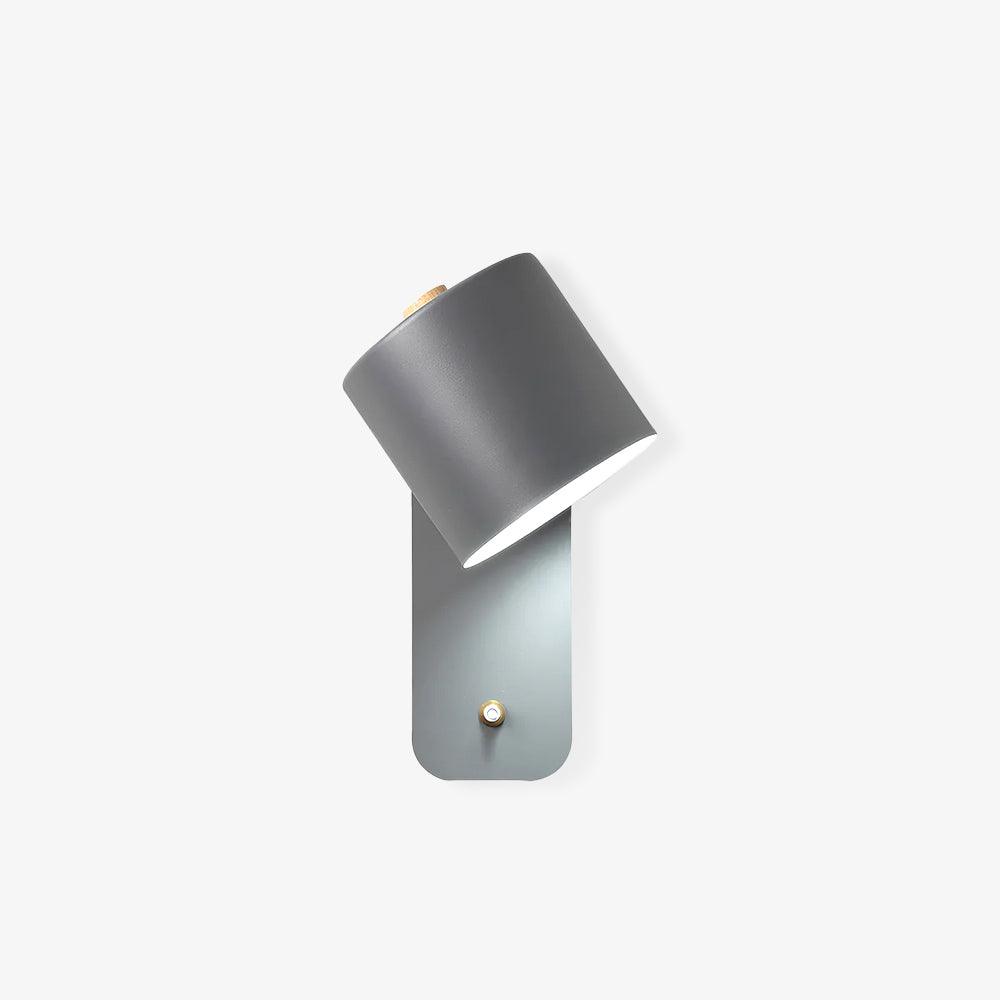 Rotatable cylinder wall sconce in modern metal finish mounted on a wall